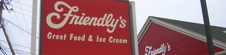 Red Friendly's Restaurant sign with Friendly's written above the tagline 'Great Food and Ice Cream' and showing a tiny bit of the Friendly's building in the background.