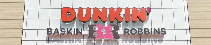 Storefront signage with orange 3D DUNKIN' letters above BASKIN 31 ROBBINS — the BR is brown with a pink 31 in the middle — mounted on a white tiled wall, showing a co-branded Dunkin' and Baskin-Robbins location.